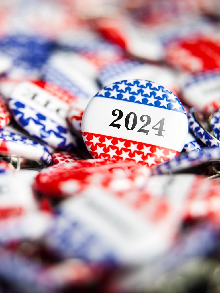 Nahaufnahme rot-blauer Buttons mit einer aufgedruckten "2024".