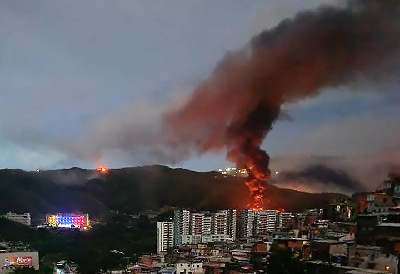 Ein Feuer auf Fuerte Tiuna, Venezuelas größtem Militärkomplex, ist nach einer Reihe von Explosionen in Caracas am 3. Januar 2026 aus der Ferne zu sehen. Ein Feuer auf Fuerte Tiuna, Venezuelas größtem Militärkomplex, ist nach einer Reihe von Explosionen in Caracas am 3. Januar 2026 aus der Ferne zu sehen.