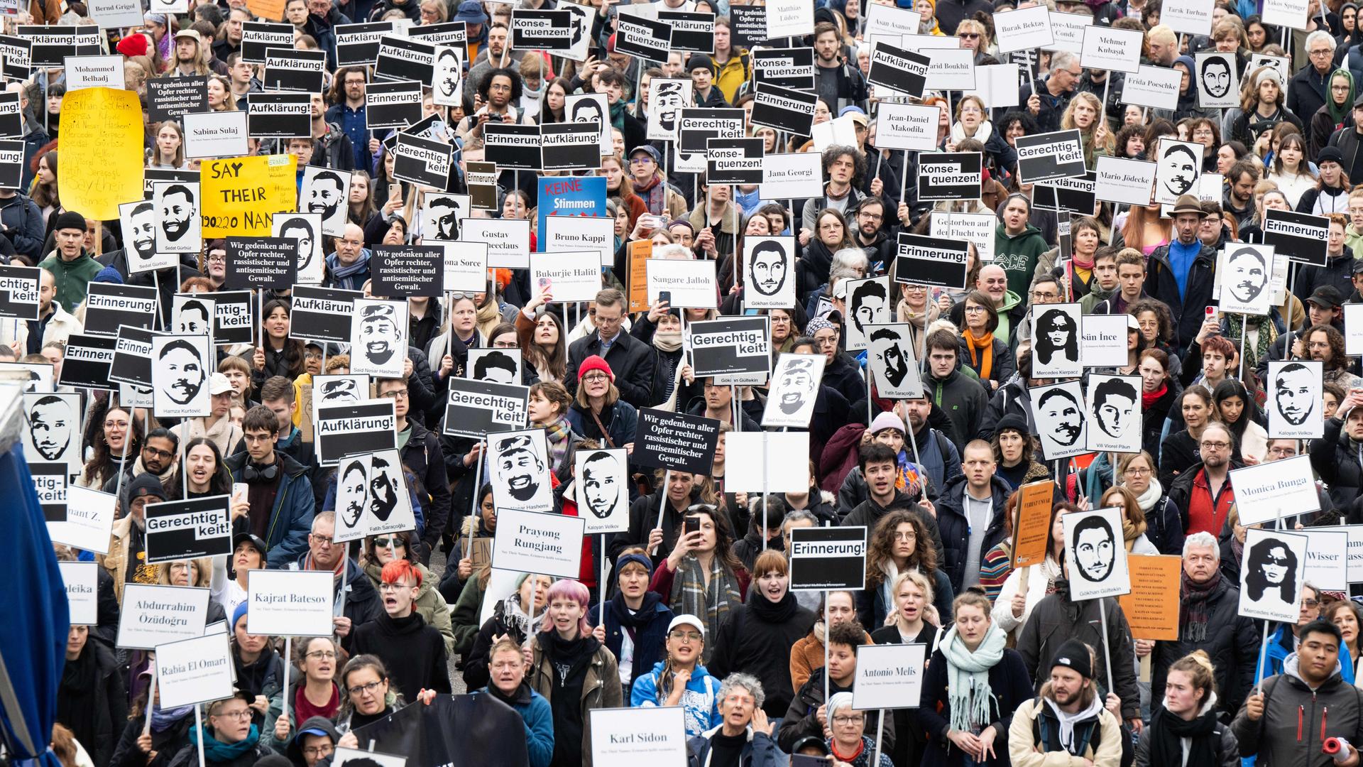 Tausende Menschen ziehen bei einem Gedenkmarsch anlässlich des vierten Jahrestages des rassistische Anschlags von Hanau durch die Innenstadt. Viele halten dabei Bilder der Opfer hoch.