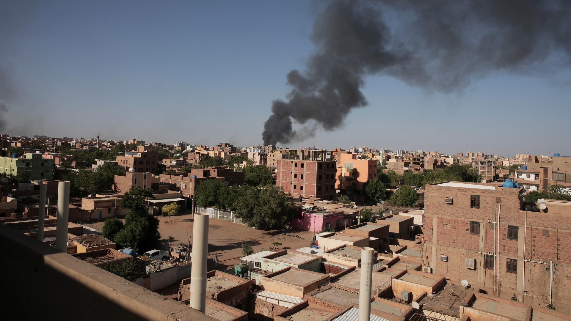 In dem Land Sudan gibt es schwere Kämpfe. Auf dem Bild ist die Haupt-Stadt Khartum. Über Häusern steigt Rauch auf.