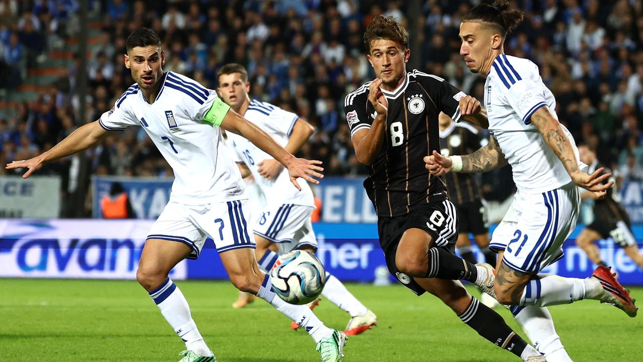 Mehrere Fussballspieler kämpfen um den Ball. 