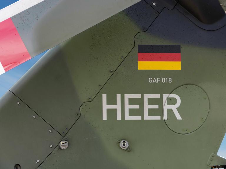 Nahaufnahme von Heck eines Bundeswehr-Hubschraubers mit Deutschlandflagge und dem Wort Heer.