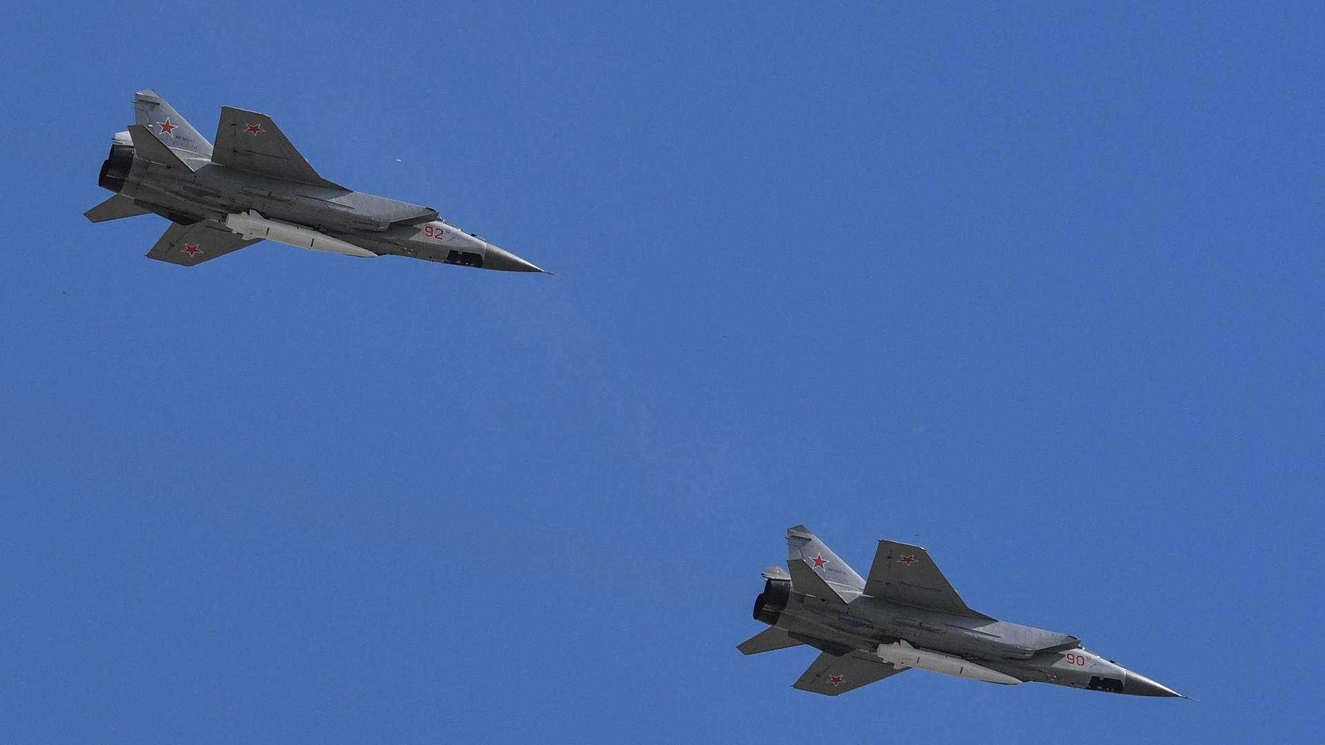 Zwei russische Kampfflugzeuge des Typs MiG-31 am blauen Himmel.