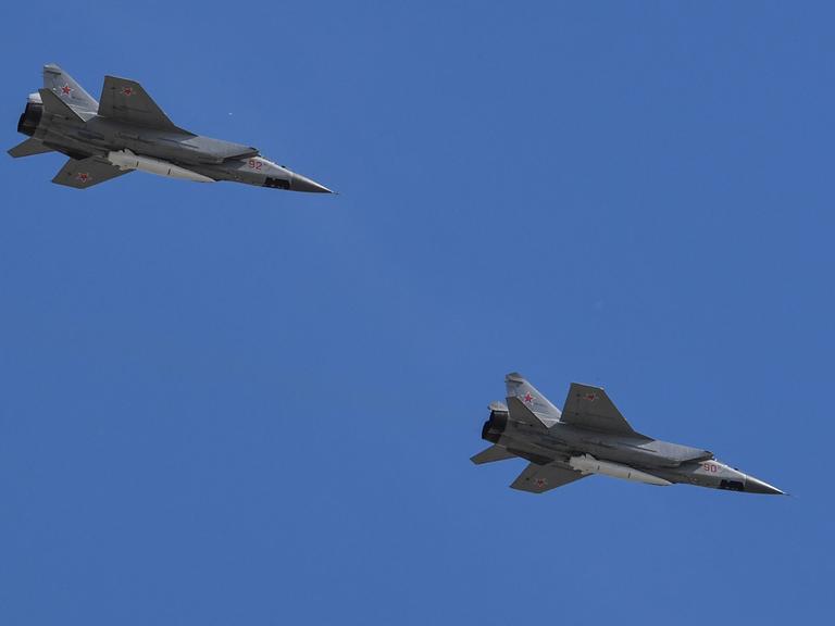 Zwei russische Kampfflugzeuge des Typs MiG-31 am blauen Himmel.