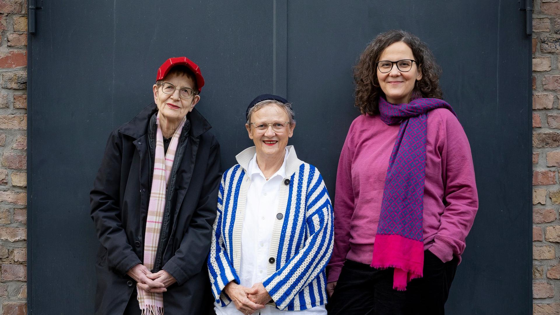 Die Kuratorinnen des Frauenfilmfestivals Remake in Frankfurt stehen vor einer grauen Tür.