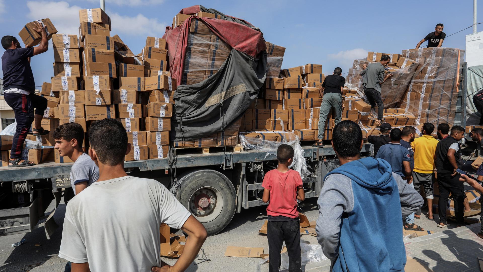 Palästinenser im Gazastreifen beim Abladen von Hilfsgütern von einem Lkw. Die Hilfsgüter kamen über den Grenzübergang Rafah zu Ägypten.