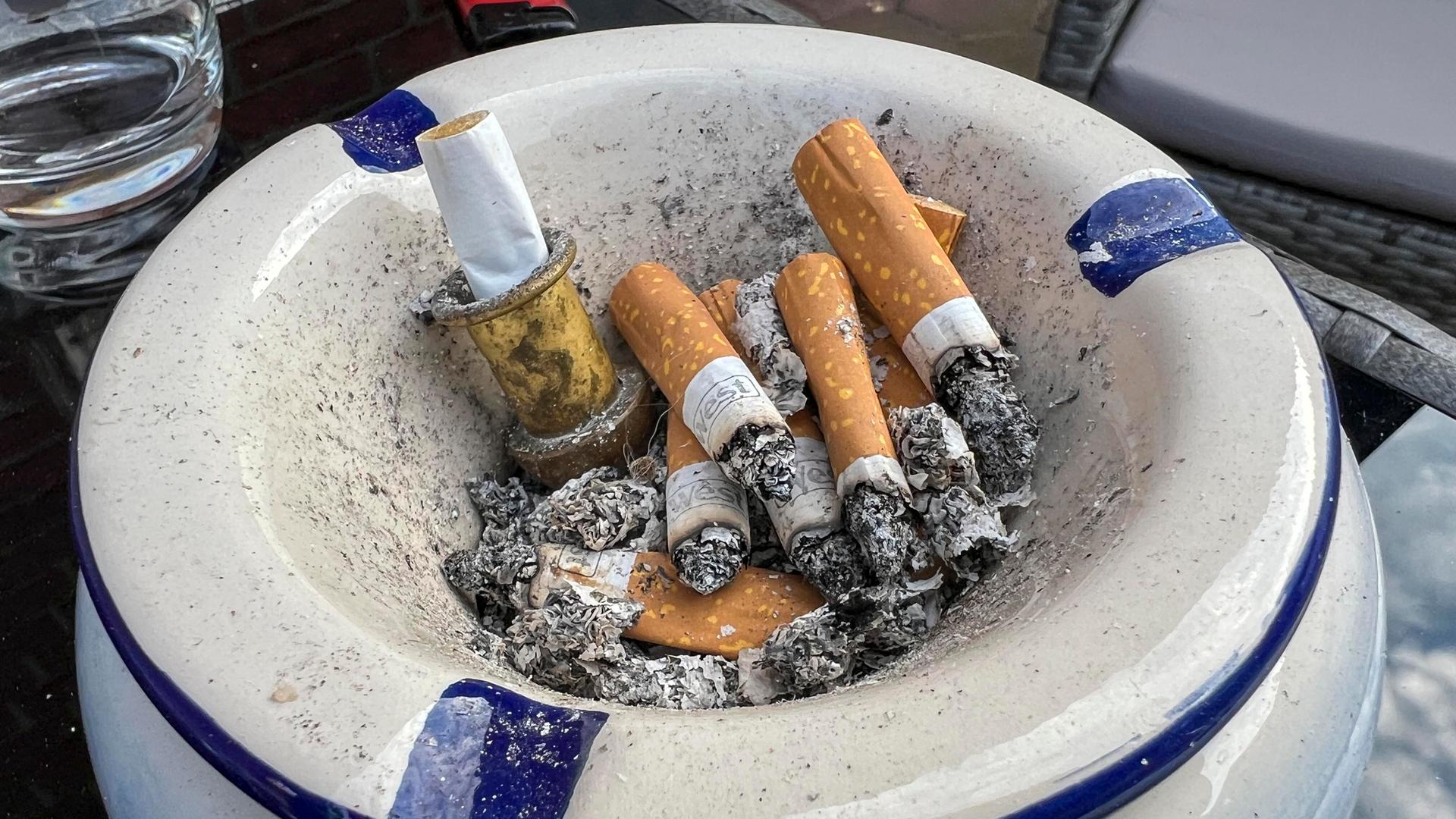 Ein Aschenbecher mit den Stummeln von Filterzigaretten.