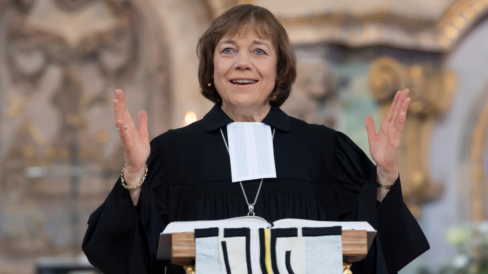 Präses Annette Kurschus, Ratsvorsitzende der Evangelischen Kirche in Deutschland, bei einer Predigt. Sie trägt einen Talar und gestikuliert mit den Händen. Präses Annette Kurschus, Ratsvorsitzende der Evangelischen Kirche in Deutschland, bei einer Predigt. Sie trägt einen Talar und gestikuliert mit den Händen.