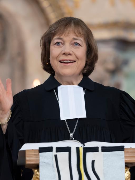 Präses Annette Kurschus, Ratsvorsitzende der Evangelischen Kirche in Deutschland, bei einer Predigt. Sie trägt einen Talar und gestikuliert mit den Händen.