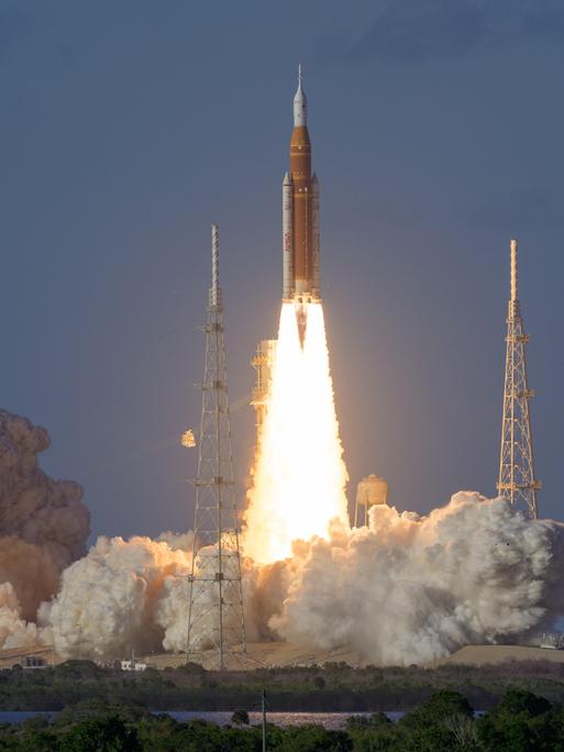 Die Orion-Rakete der Mondflugmission Artemis II startet mit einem Feuerschweif vom John-F.-Kennedy-Weltraumbahnhof in Florida in den Abendhimmel.