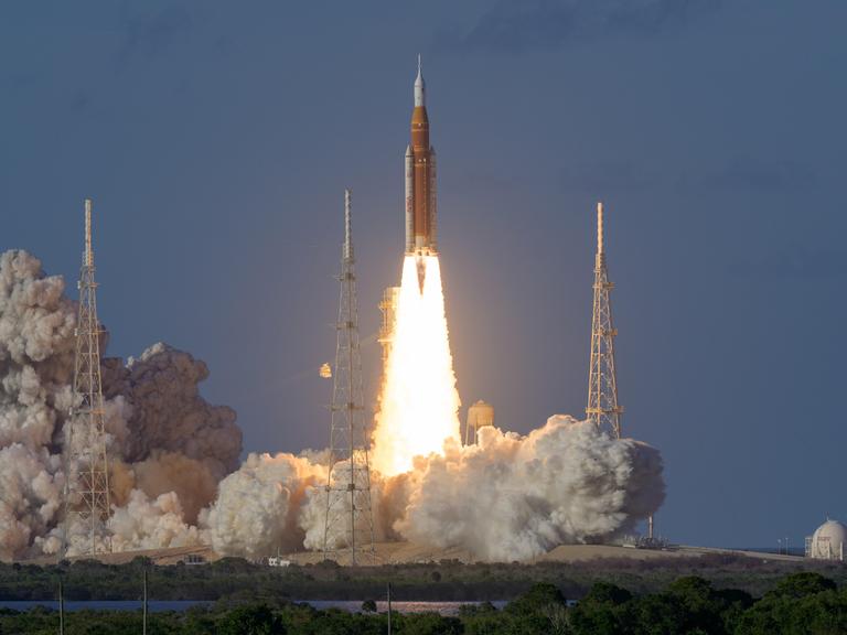 Die Orion-Rakete der Mondflugmission Artemis II startet mit einem Feuerschweif vom John-F.-Kennedy-Weltraumbahnhof in Florida in den Abendhimmel.
