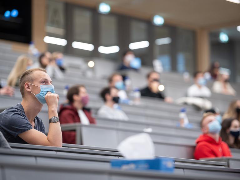 Studierende mit Mundschutz in Hörsaal
