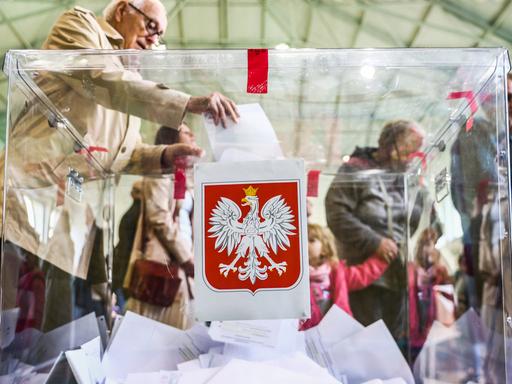 Wähler und Wäherlinnen geben im polnischen Krakau ihrer Stimme für die Parlamentswahl in Polen ab
