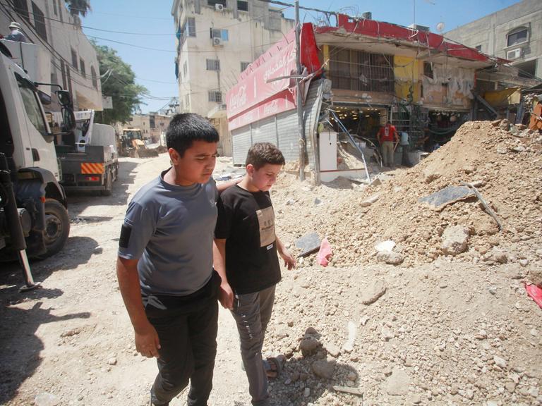 Zwei Kinder laufen an Trümmern im Gazastreifen vorbei. 