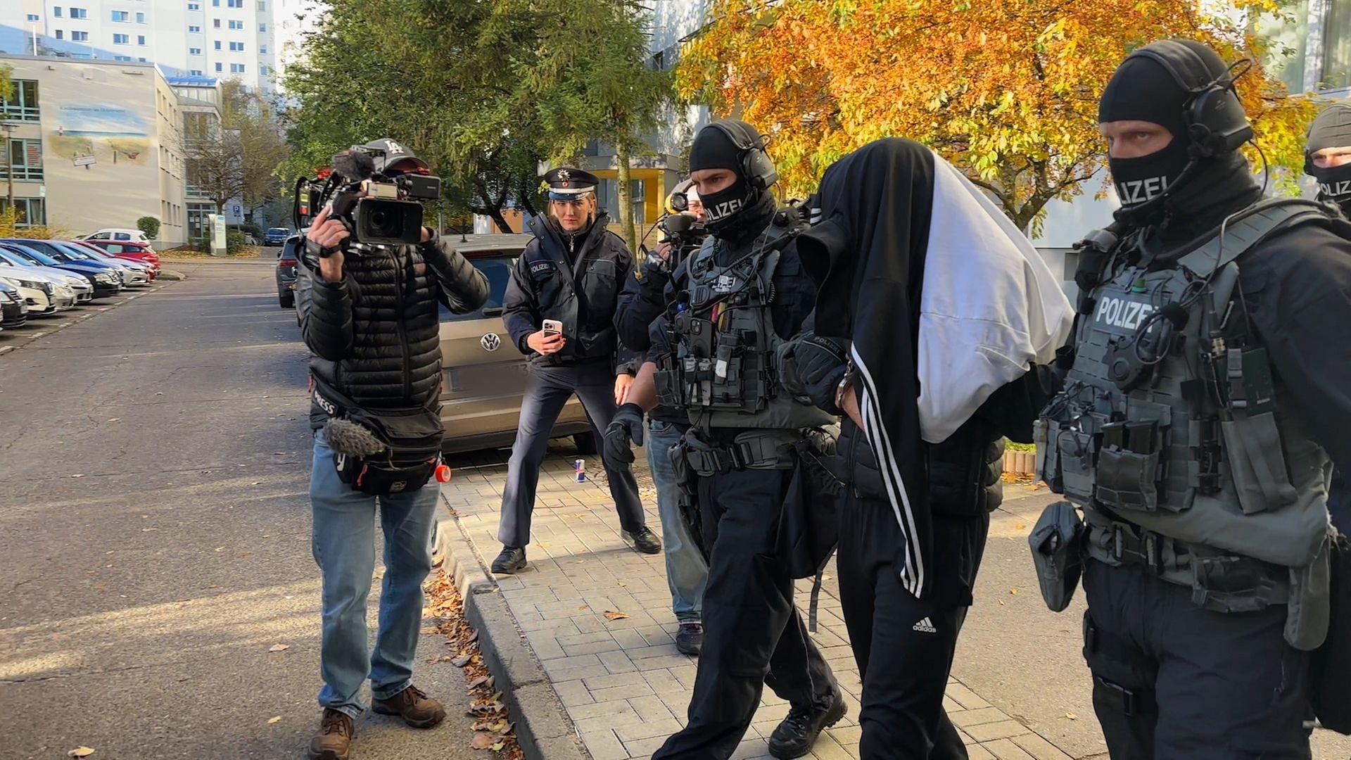 Berlin: Spezialkräfte verlassen mit einer festgenommenen Person bei einer großangelegten Razzia der Bundespolizei und Landespolizei Brandenburg ein Haus in Weißensee (Videostandbild). Berlin: Spezialkräfte verlassen mit einer festgenommenen Person bei einer großangelegten Razzia der Bundespolizei und Landespolizei Brandenburg ein Haus in Weißensee (Videostandbild).