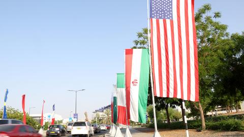 Die Flaggen der USA und des Irans an einer Straße in Maskat im Oman. 