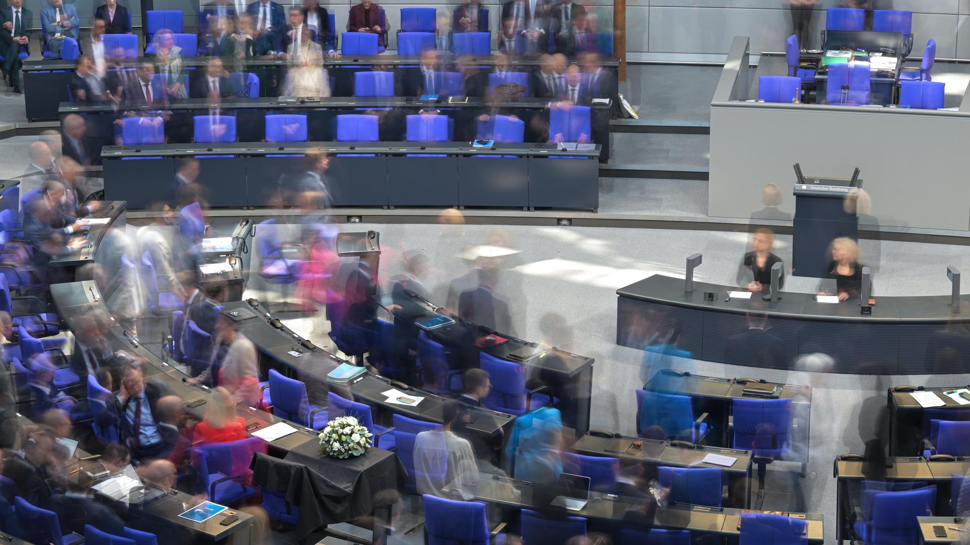 Blick in den Plenarsaal des Bundestages. Das Parlament kommt zu seiner letzten regulären Sitzung vor der Bundestagswahl 2025 zusammen. Die Aufnahme wurde mit Langzeitbelichtung gemacht, so dass einzelne Personen verschwommen sind.