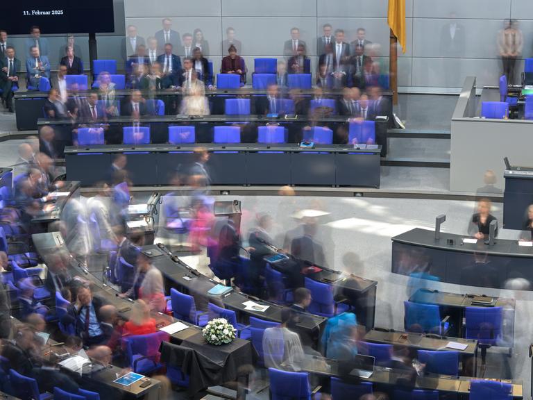 Blick in den Plenarsaal des Bundestages. Das Parlament kommt zu seiner letzten regulären Sitzung vor der Bundestagswahl 2025 zusammen. Die Aufnahme wurde mit Langzeitbelichtung gemacht, so dass einzelne Personen verschwommen sind.