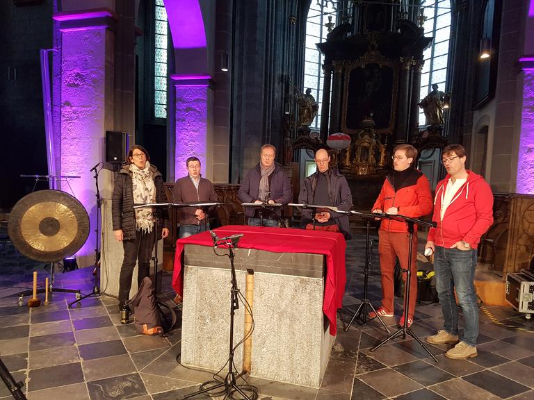 Man sieht das Ensemble Singer Pur beim Soundcheck vor einem Altar stehend. 