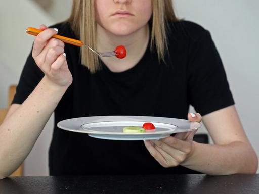 Frau pickt Tomaten von fast leerem Teller