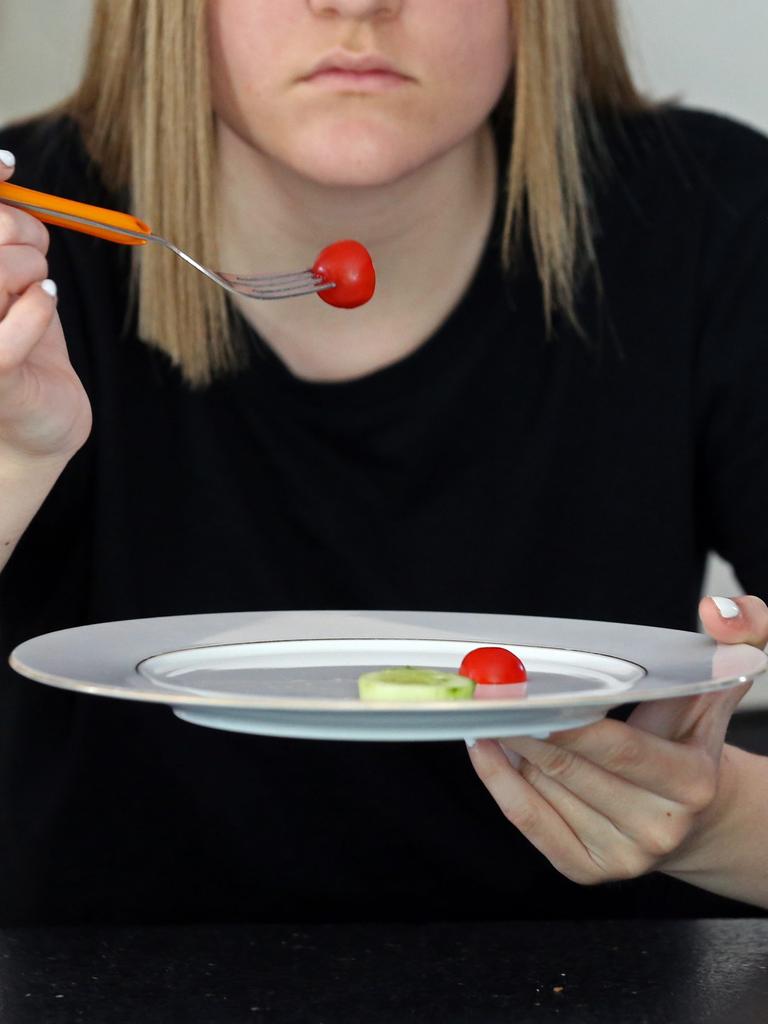 Frau pickt Tomaten von fast leerem Teller