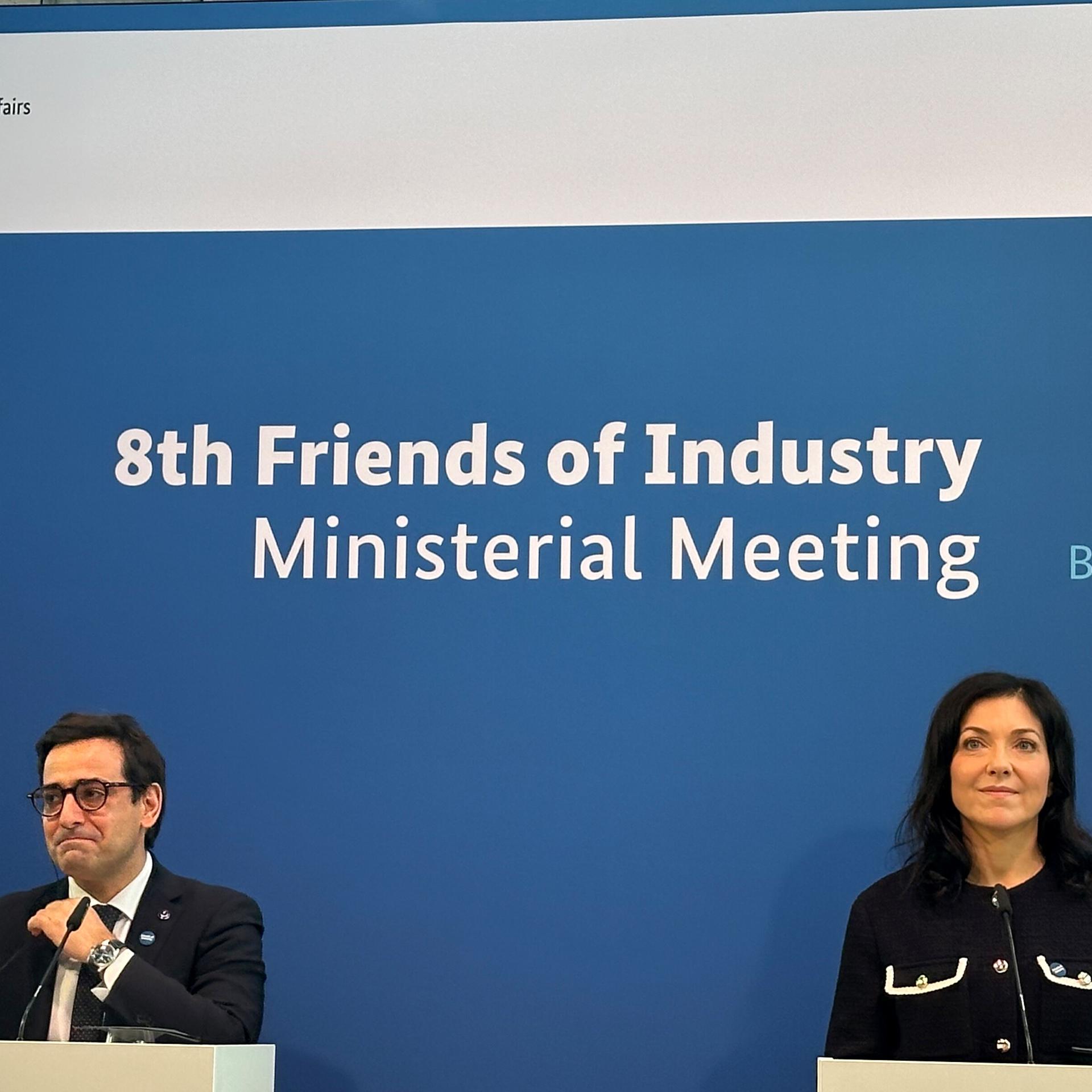 Bundeswirtschaftsministerin Katherina Reiche (r., CDU) und der Exekutiv-Vizepräsident der EU-Kommission, Stéphane Séjourné (l.) sitzen vor einer blauen Wand mit der Aufschrift "8th Friends of Industry Ministerial Meeting".