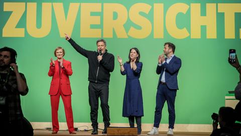 Robert Habeck, Franziska Brantner, Annalena Baerbock und Felix Banaszak stehen auf einer Bühne des Parteitags der Grünen in Berlin.