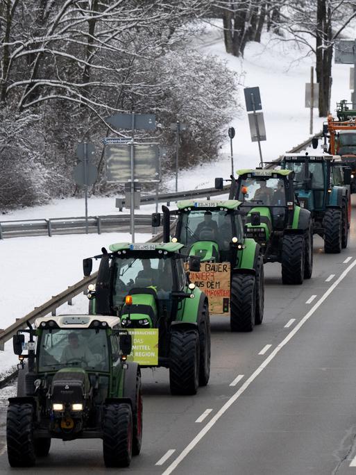 Traktoren fahren während einer Demonstration von Landwirten in der Innenstadt über den Mittleren Ring in München.