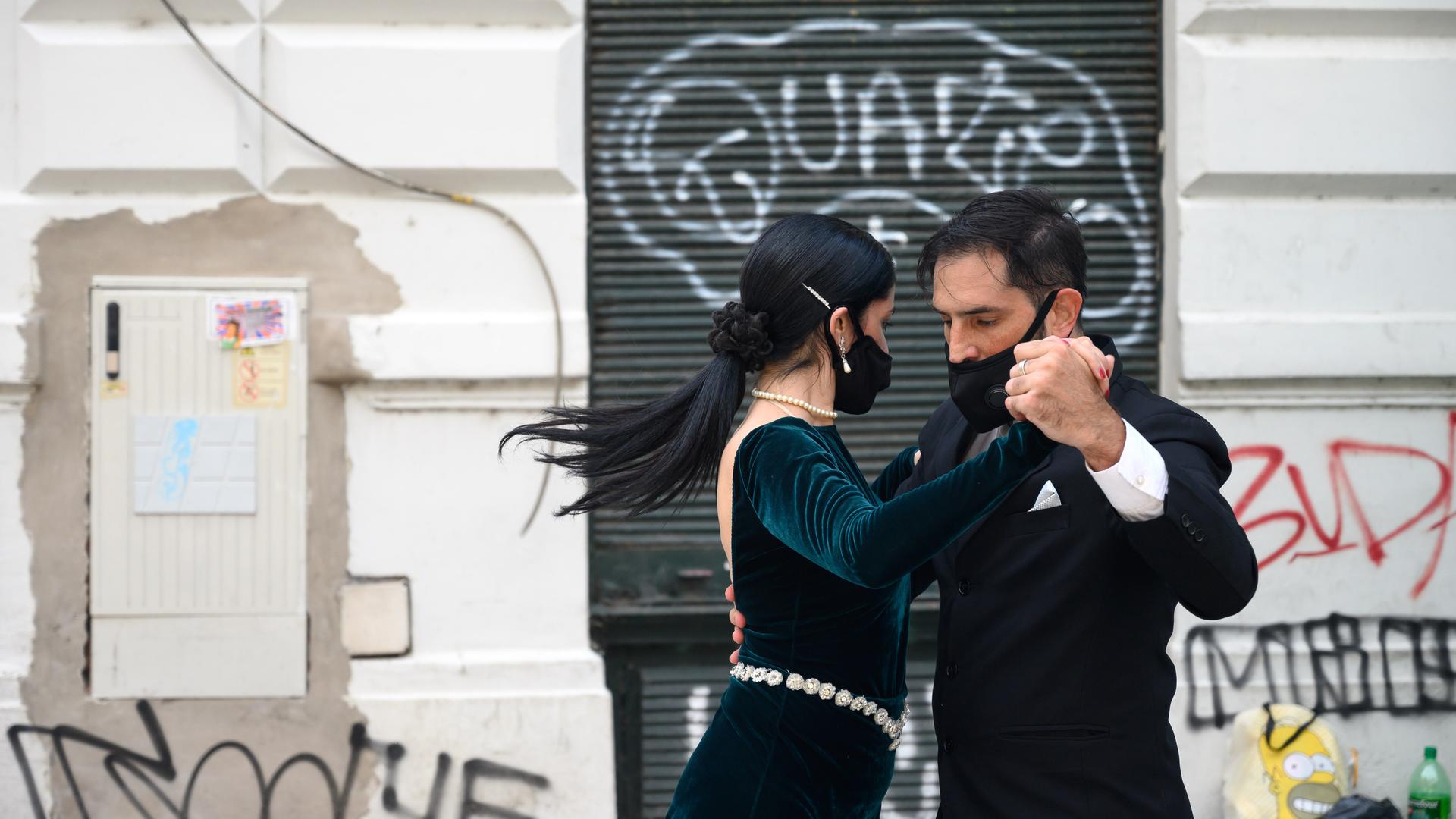 Ein Paar tanzt mit Schutzmasken im Gesicht in San Telmo in Buenos Aires Tango.