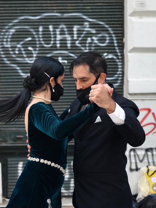 Ein Paar tanzt mit Schutzmasken im Gesicht in San Telmo in Buenos Aires Tango.