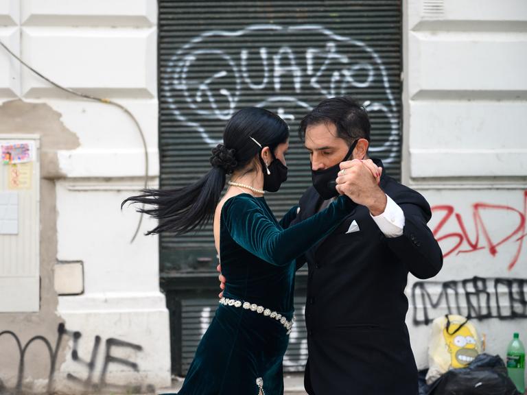 Ein Paar tanzt mit Schutzmasken im Gesicht in San Telmo in Buenos Aires Tango.