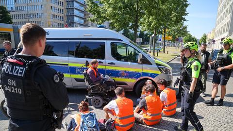 Klimaaktivisten protestieren mit einer Sitzblockade gegen den Prozess gegen fünf Mitglieder der Letzten Generation.
