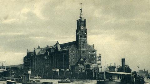 Ein zeitgenössisches Schwarz-Weiß-Foto zeigt den Kaiserspeicher an der Elbe im Hamburger Hafen mit dem Zeitball auf der Spitze des Turmes.
