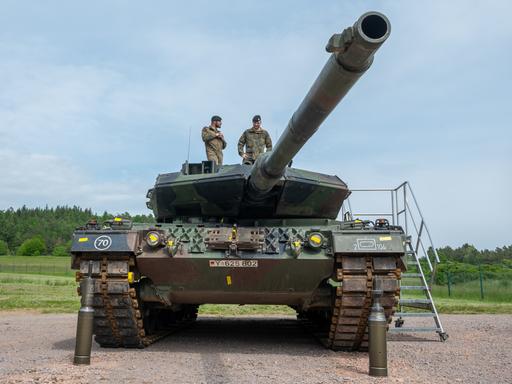 Ein Kampfpanzer auf dem zwei Soldaten stehen. Vor dem Fahrzeug steht Munition. Ein Kampfpanzer auf dem zwei Soldaten stehen. Vor dem Fahrzeug steht Munition.