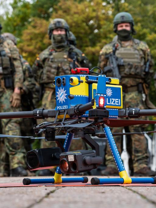 Gemeinsame Einsatzübung der Bayerischen Polizei und der Deutschen Bundeswehr RoadTEX 2025 (Übung Anschlag im Verkehrsraum). Eine Polizeidrohne steht einsatzbereit vor einer Formation von Bundeswehrsoldaten Gemeinsame Einsatzübung der Bayerischen Polizei und der Deutschen Bundeswehr RoadTEX 2025 (Übung Anschlag im Verkehrsraum). Eine Polizeidrohne steht einsatzbereit vor einer Formation von Bundeswehrsoldaten