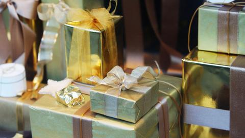 In einem Schaufenster liegen golden verpackte Geschenke für Weihnachten.