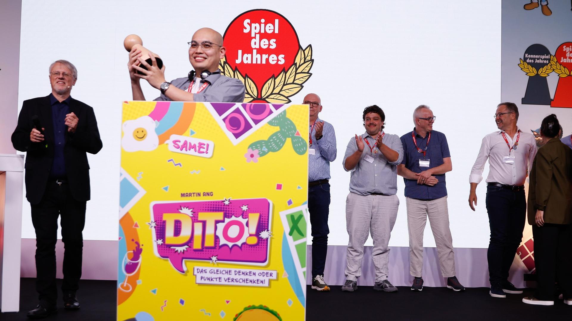 Martin Ang, Gewinner des "Spiel des Jahres 2026" mit dem Spiel "Dito!" jubelt neben Harald Schrapers, Vorsitzender des Vereins "Spiel des Jahres", während der Preisverleihung in Berlin.