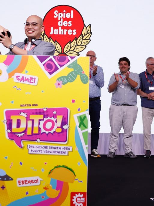 Martin Ang, Gewinner des "Spiel des Jahres 2026" mit dem Spiel "Dito!" jubelt neben Harald Schrapers, Vorsitzender des Vereins "Spiel des Jahres", während der Preisverleihung in Berlin.