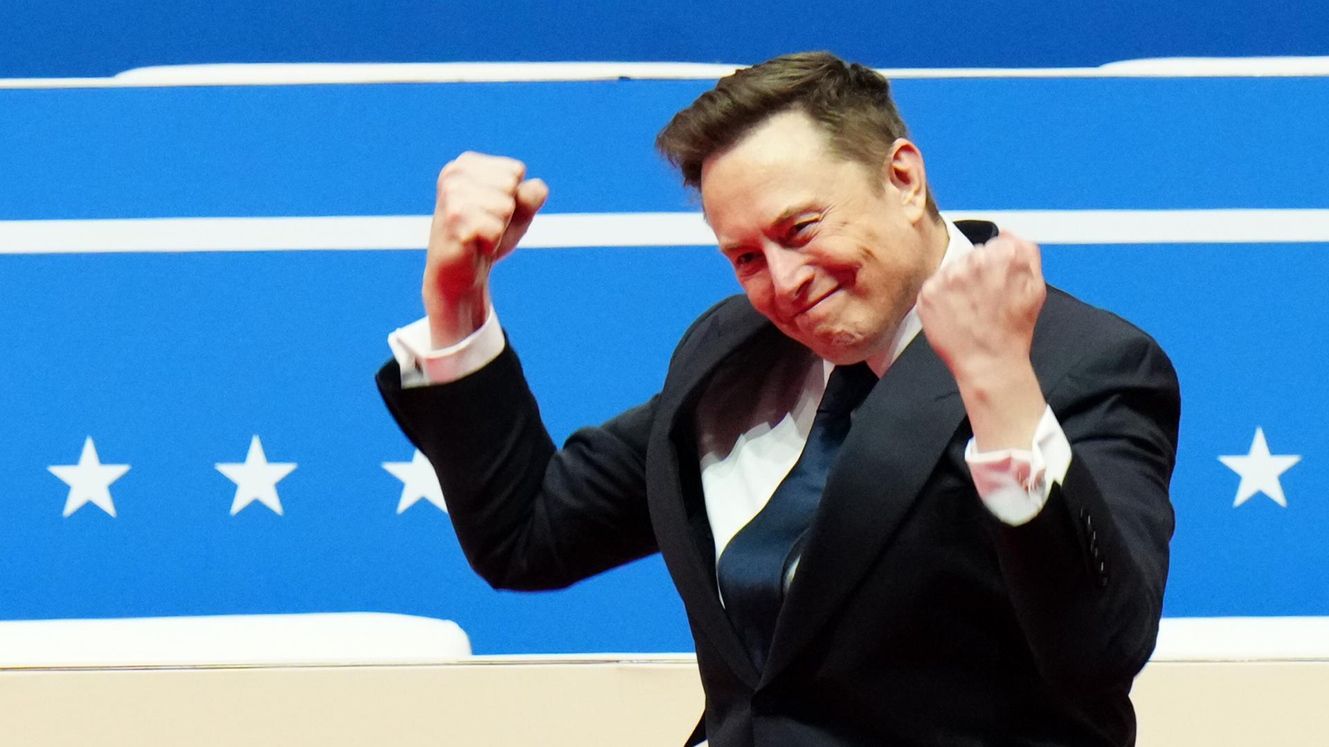 Elon Musk hat die Hände jubelnd zu Fäusten geballt.