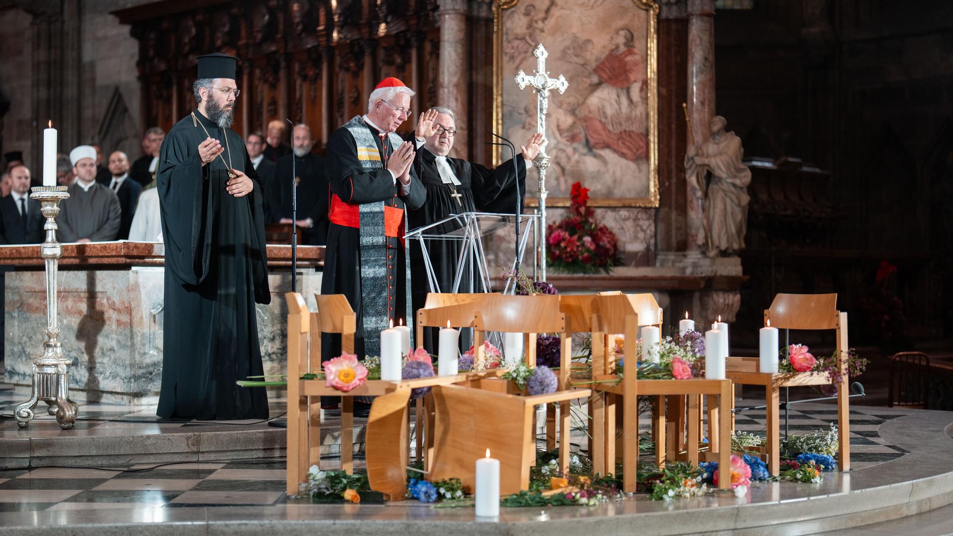 Geistliche stehen zwischen Altar und einer improvisierten Gedenkstätte aus Stühlen, Blumen und Kerzen Geistliche stehen zwischen Altar und einer improvisierten Gedenkstätte aus Stühlen, Blumen und Kerzen