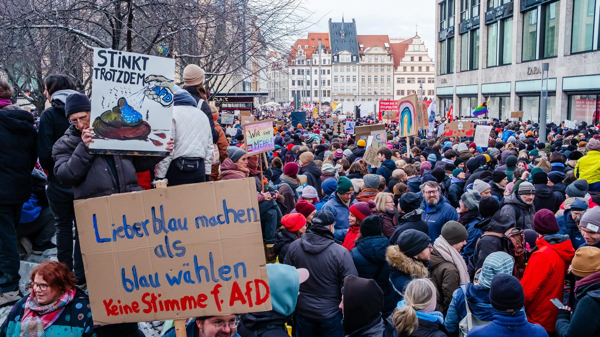 Demonstranten mit Plakaten haben sich in der Petersstrasse und rund um den Marktplatz von Leipzig versammelt.
