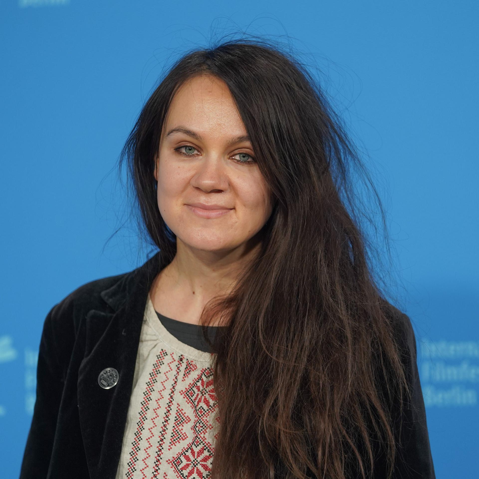 Die Drehbuchautorin Anna Melikova steht bei der Berlinale 2022 auf der Bühne vor einer blauen Wand