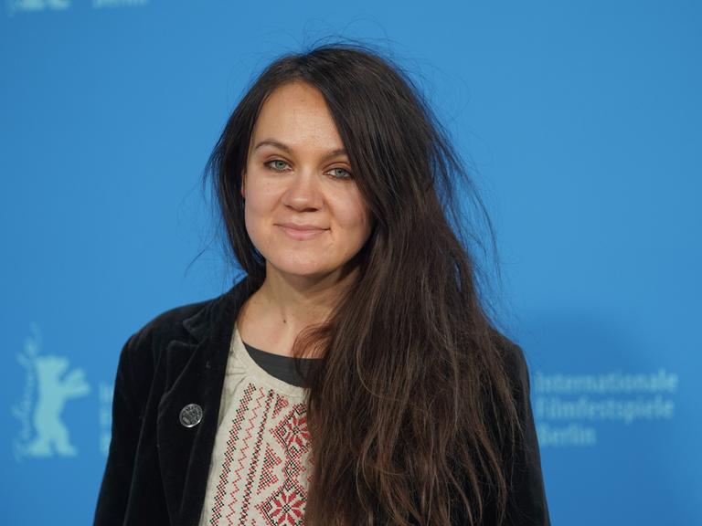 Die Drehbuchautorin Anna Melikova steht bei der Berlinale 2022 auf der Bühne vor einer blauen Wand