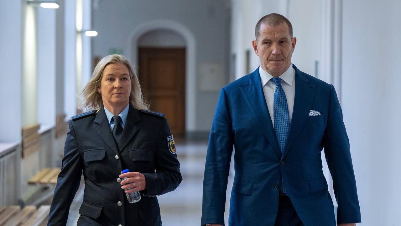 Claudia Pechstein geht vor Prozessbeginn in ihrer Polizeiuniform mit ihrem Lebensgefährten Matthias Große über den Flur des Oberlandesgerichtes München.