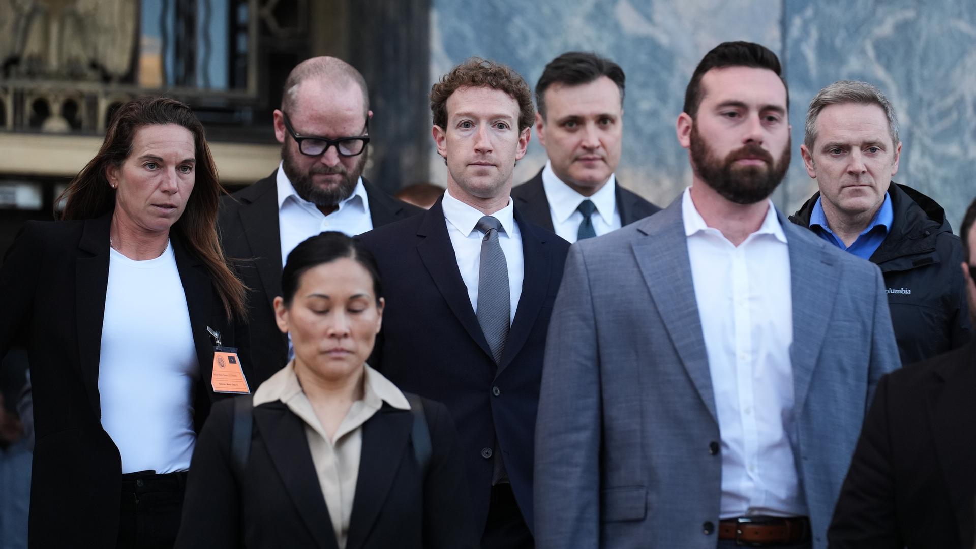 Meta-Ceo Mark Zuckerberg in einer Gruppe anderer Menschen in Business-Kleidung vor einem Gebäude