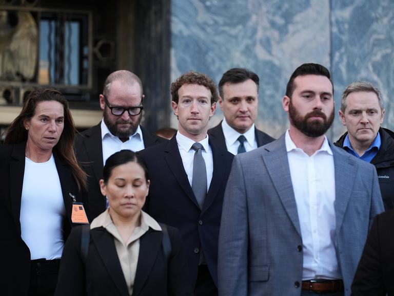 Meta-Ceo Mark Zuckerberg in einer Gruppe anderer Menschen in Business-Kleidung vor einem Gebäude