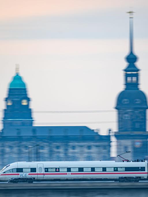 Ein ICE-Zug der Deutschen Bahn fährt am Morgen vor der Altstadtkulisse über die Marienbrücke.