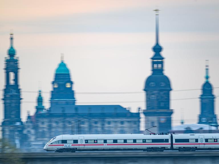 Ein ICE-Zug der Deutschen Bahn fährt am Morgen vor der Altstadtkulisse über die Marienbrücke.