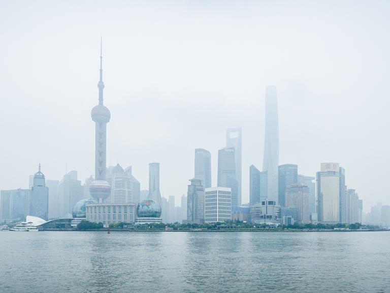 Blick auf Shanghai im Nebel, im Vordergrund ist Wasser zu sehen