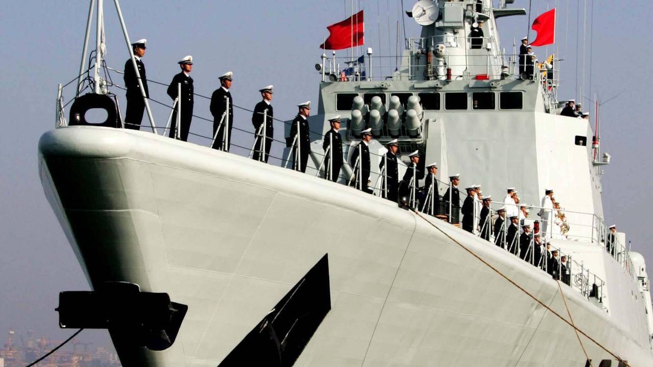 Soldaten stehen aufgereiht an der Reling eines chinesischen Kriegsschiffs. 
